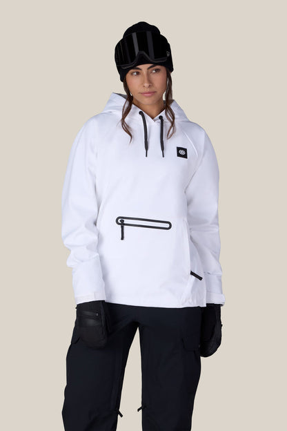 A person wearing the 686 Women’s Waterproof Hoody by 686, paired with black gloves, black pants, and a black beanie with goggles on top, stands against a plain beige background.