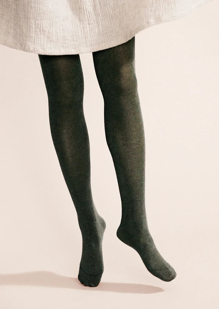 A person wearing knit tights in green.