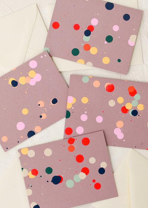 Four pink cards with colorful polka dots on a white surface