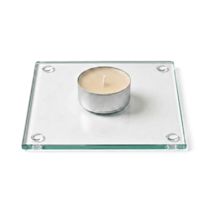 A clean product studio shot of an unlit candle sitting on a clear glass Square Coaster 4"