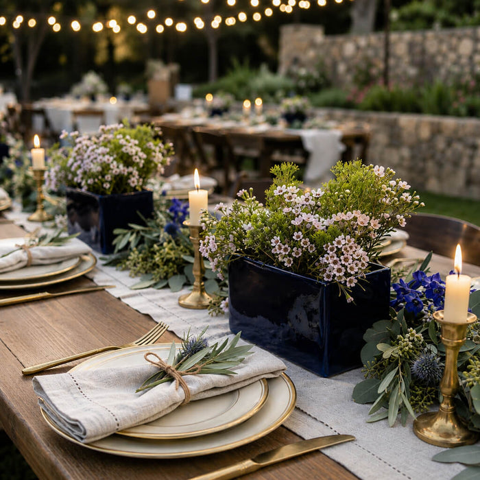 Navy blue square vases filled with light pink waxflowers as table centerpieces