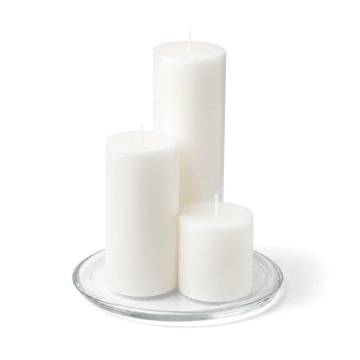 8" Round Glass Pillar Plate with three white pillar candles on a white background