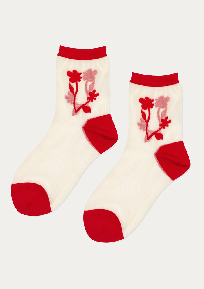 A pair of sheer nylon socks with red floral pattern.