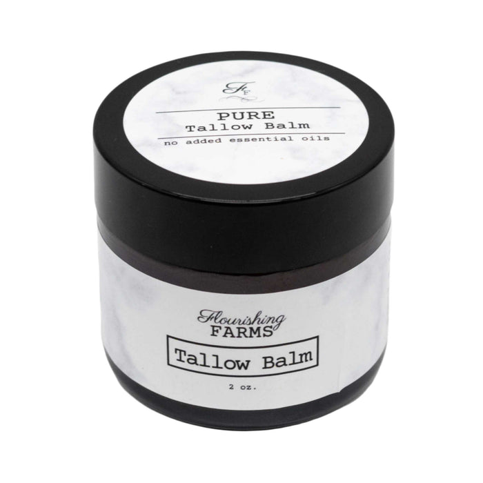 Tallow balm jar with black lid and white label on a white background